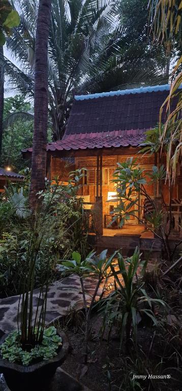 吉利特拉旺安Villas Light House - Eco-Traditional Joglo的花园中带紫色屋顶的木屋