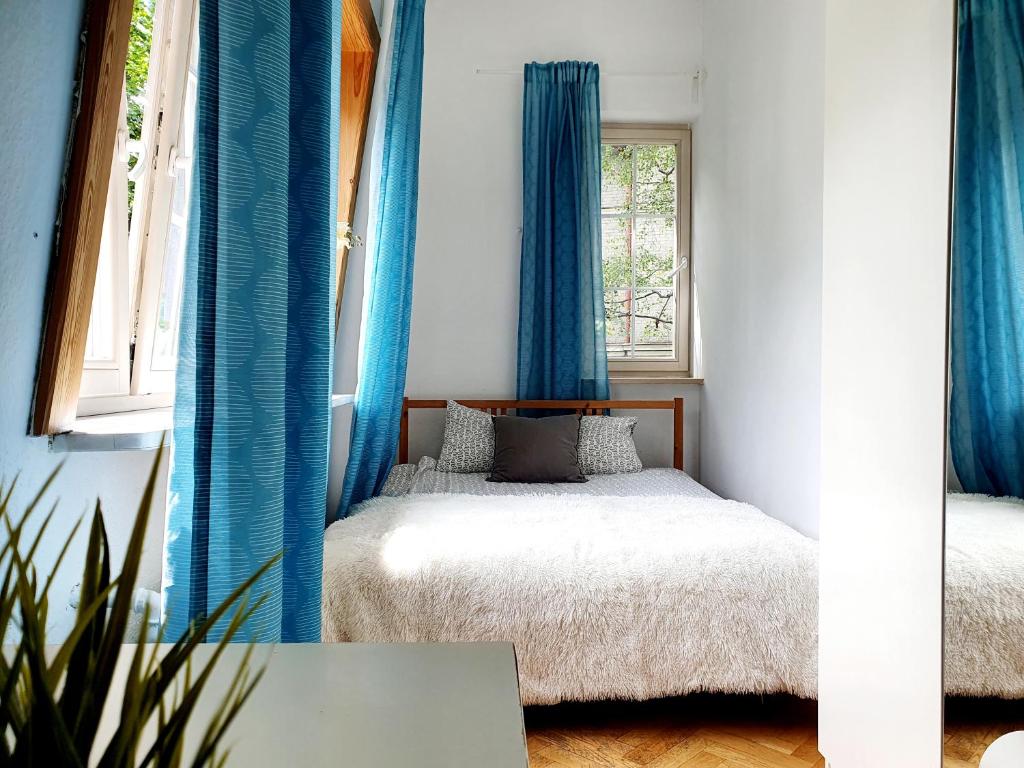 索波特Tanie pokoje w centrum的一间小卧室,配有蓝色窗帘和床