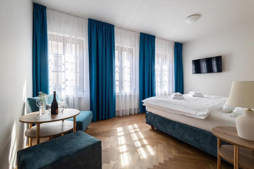 米库洛夫Hotel Tanzberg Mikulov的一间卧室配有蓝色窗帘、一张床和一张桌子