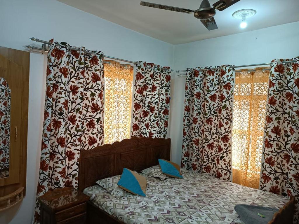 斯利那加The Hotel "Shafeeq" Across jawahar bridge的一间卧室配有床和带窗帘的窗户
