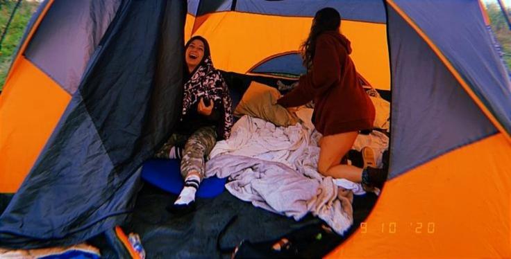 伊察Bugambilia glamping的两个女人躺在帐篷里的床上