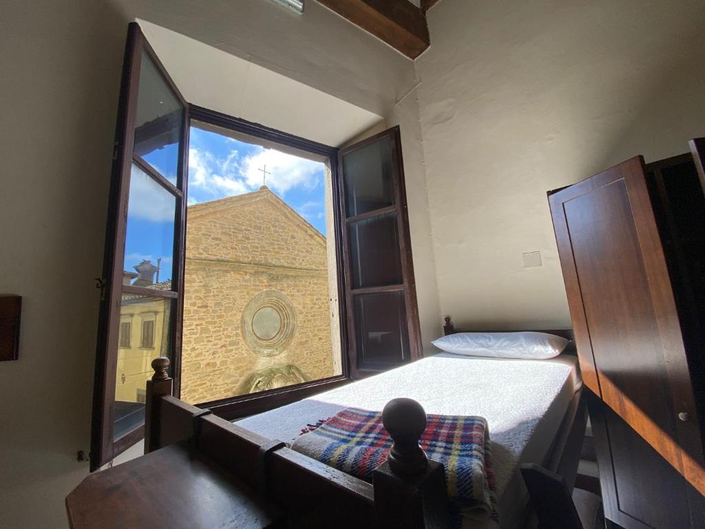 科尔托纳Ostello San Marco Cortona的一间卧室设有大窗户,享有建筑的景色