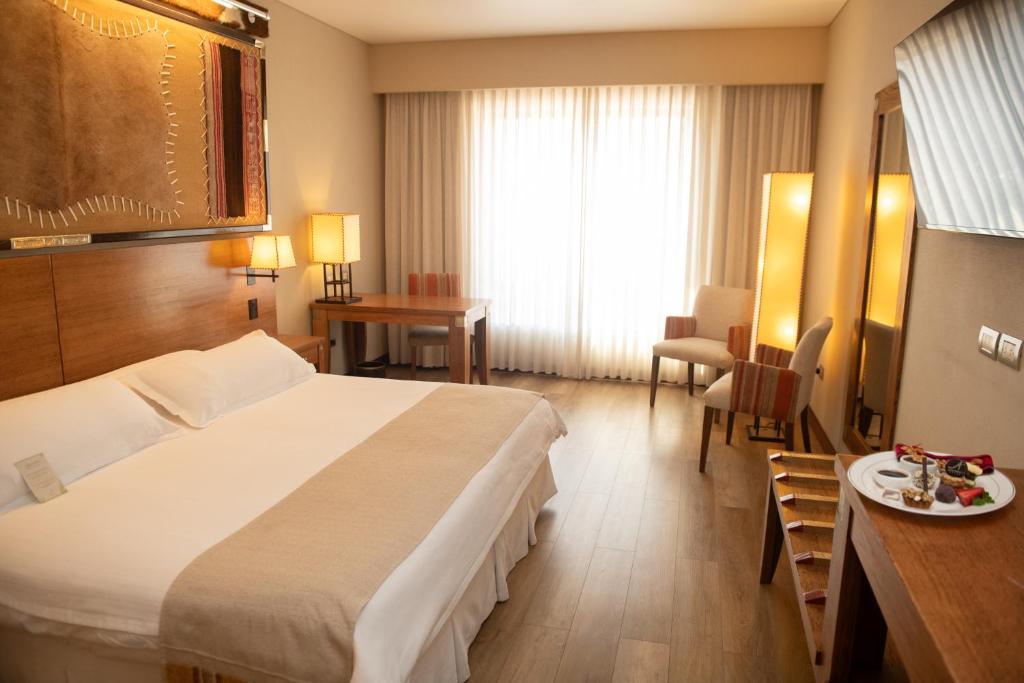 萨尔塔亚历桑德一世酒店的酒店客房设有一张大床和一张桌子。