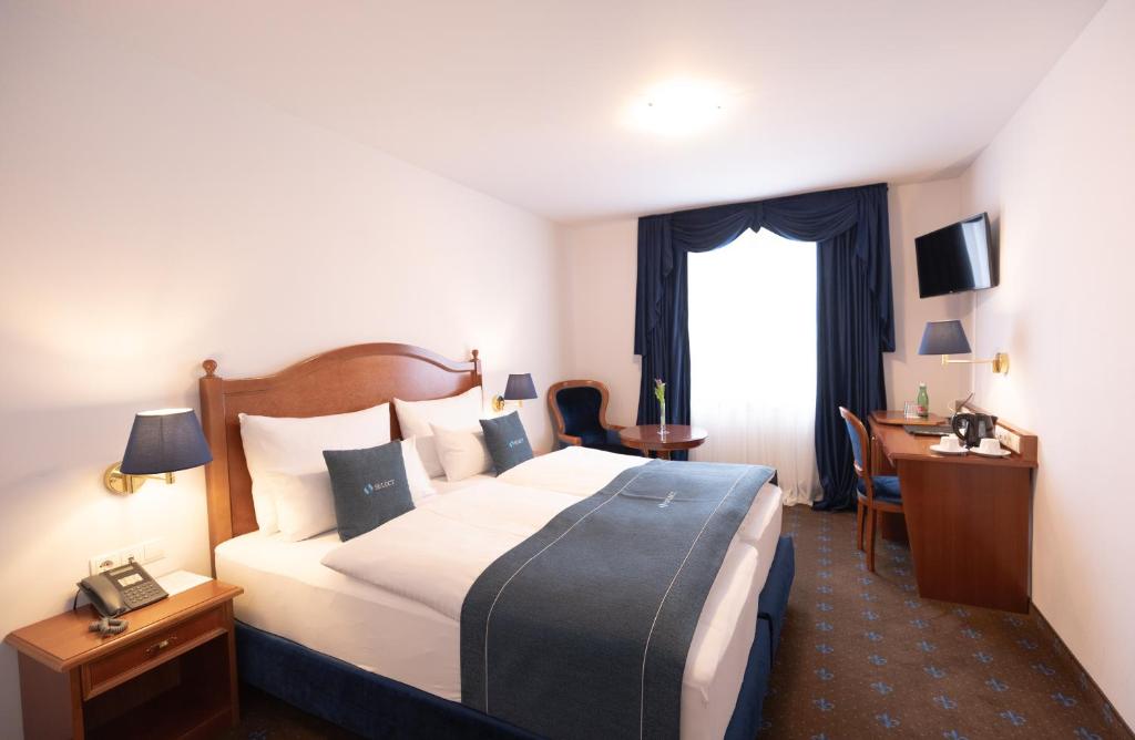 维也纳Select Hotel Prinz Eugen Wien的酒店客房设有一张大床和一张书桌。