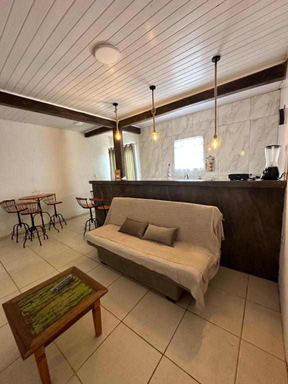 萨夸雷马Residência Saquarema的卧室配有一张床和一张桌子及椅子