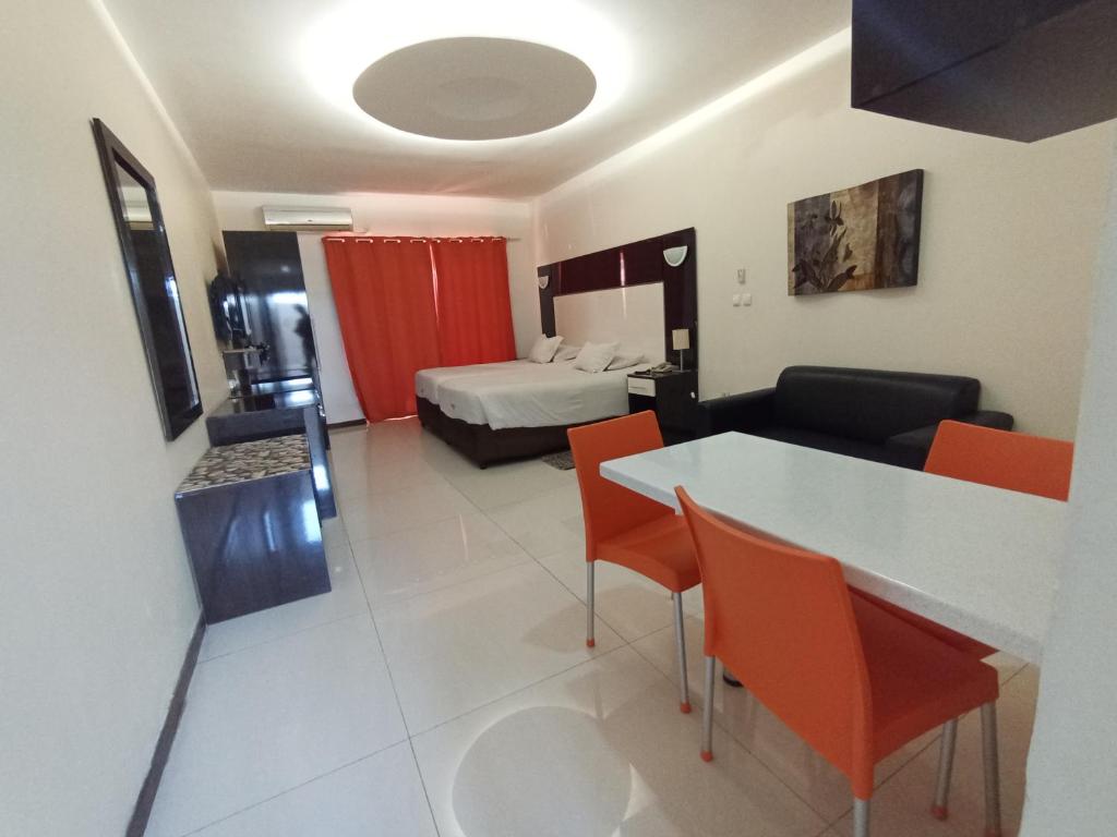 马普托Pensao Martins的酒店客房带一张床、一张桌子和椅子