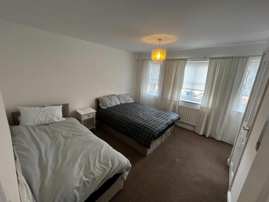 西部德比Modern 3 Bedroom House Close to Liverpool Centre的一间卧室设有两张床和窗户。
