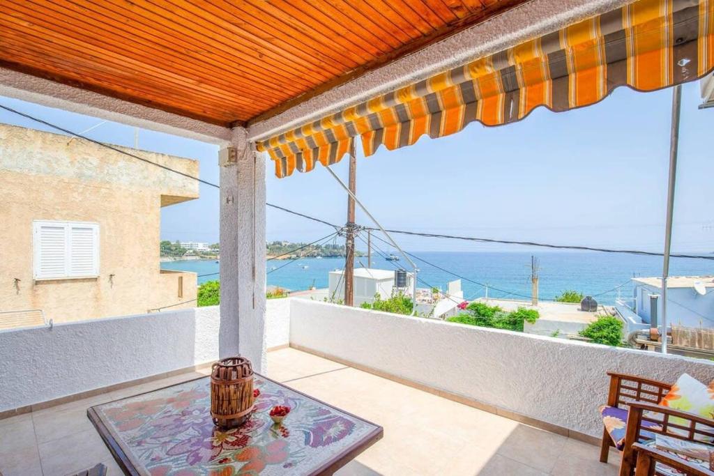 阿齐亚佩拉加Agia Pelagia Blue Apt with Seaview 50m from Sea的阳台配有桌子,享有海景。