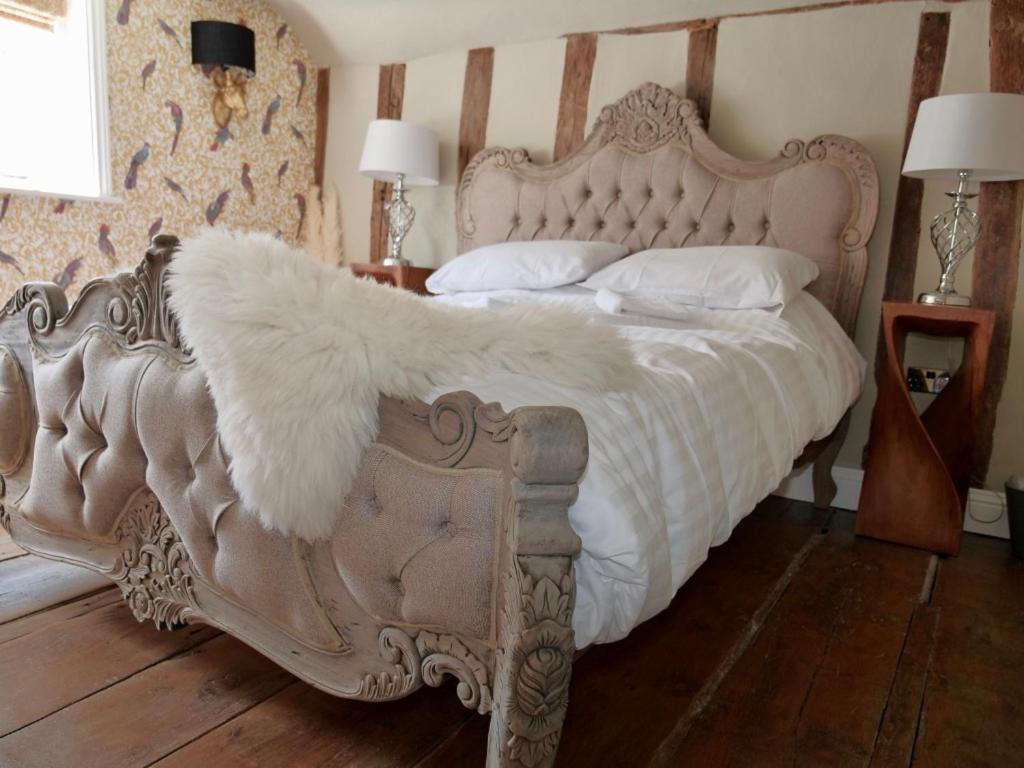 萨弗伦沃尔登Contractors Deluxe Essex Short Stay House的一张带白色棉被和枕头的床