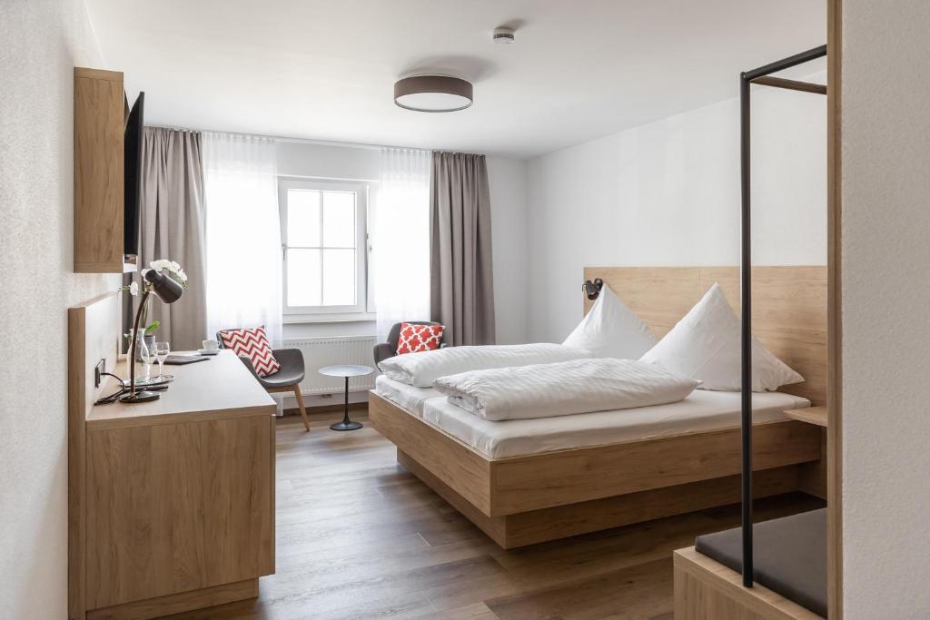 Gasthof Zum Roten Haus的配有一张床和一张书桌的酒店客房