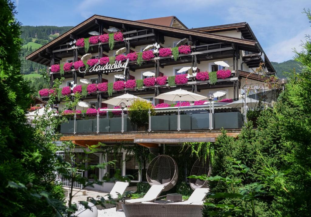 菲根Boutique Hotel Haidachhof superior的前面有椅子和鲜花的酒店