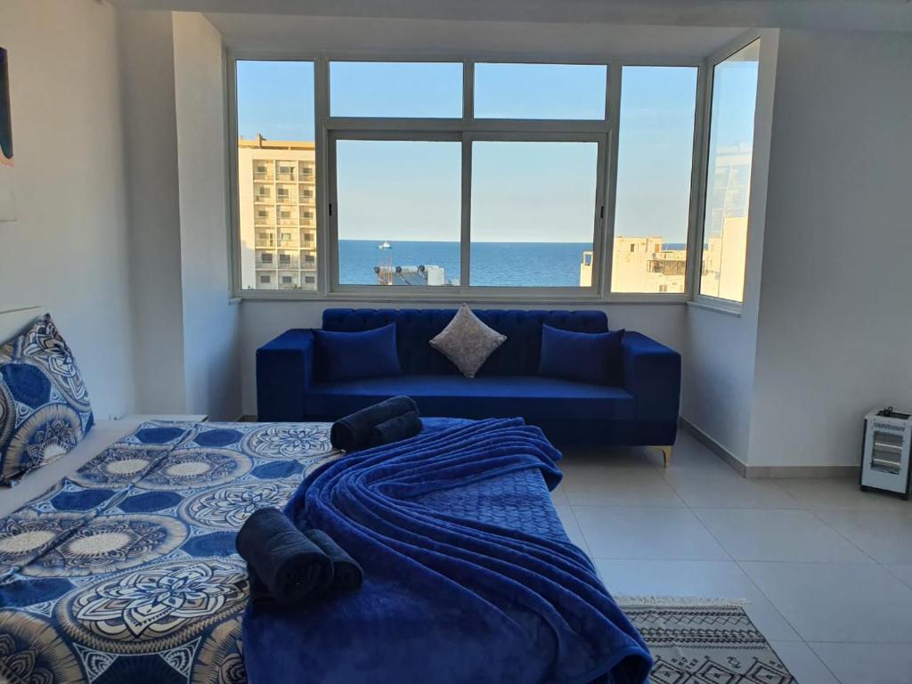 苏塞Stunning Penthouse with Sea and Castle View (2BDR)的一间卧室配有蓝色的床和蓝色的沙发