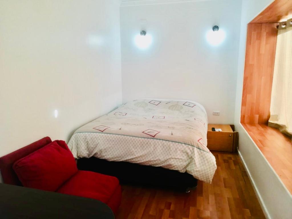 普孔Cabañas Céntricas 2的一间小卧室,配有一张床和一张红色的沙发