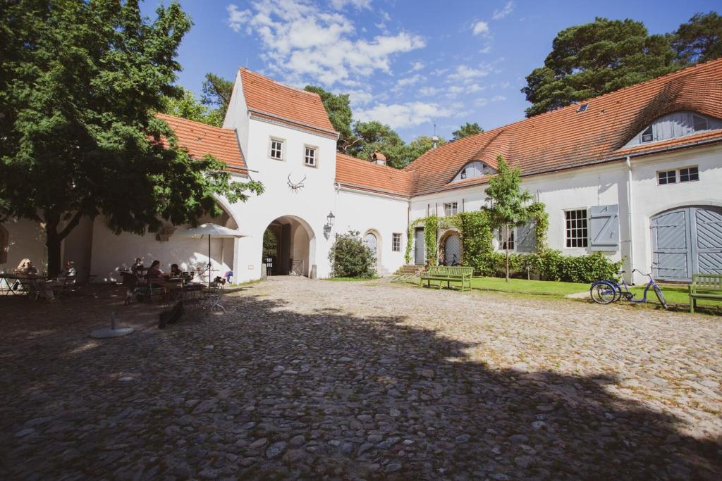 柏林Ferienwohnung Jagdschloss Grunewald的白色建筑的庭院,有树