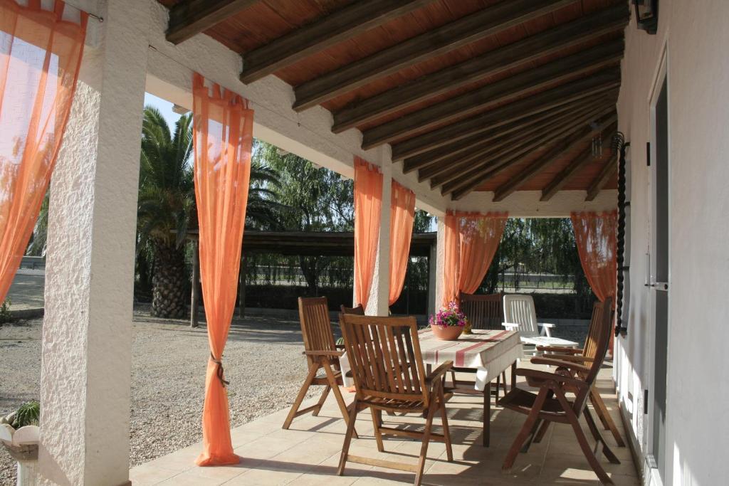 代尔特布雷卡西利亚酒店的庭院配有桌子和椅子,庭院内有橙色窗帘