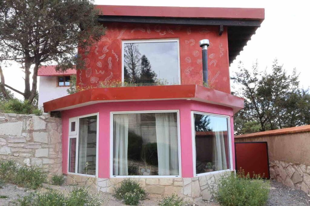 米内拉尔德尔蒙特Suite Campestre Real del Monte的一间红色的房子,上面有窗户