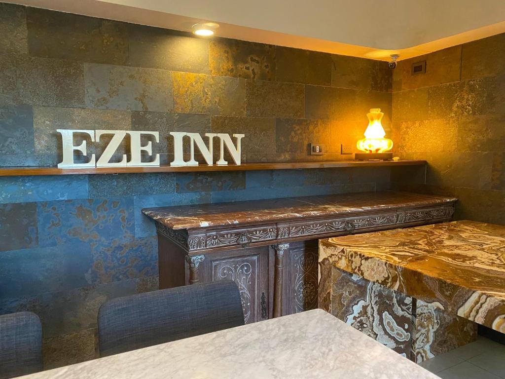 埃塞萨EZE Inn Boutique Hotel的墙上有桌子和标志的餐厅