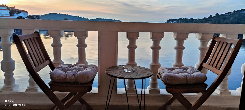 波梅纳Adio Mare~Soba~的俯瞰水面的阳台配有两把椅子和一张桌子