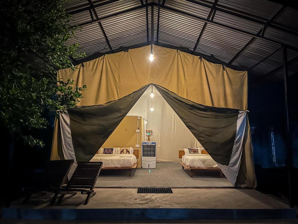 索拉哈Glampin By Tharu Garden的卧室内的帐篷 - 带两张床