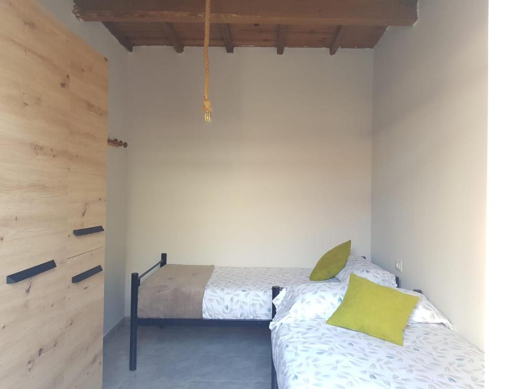 奥波里尼奥Casa La Porriñesa的一间卧室配有一张带黄色枕头的床