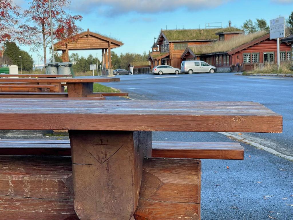 奥普达尔Oppdalsporten Motell的停车场前的木餐桌