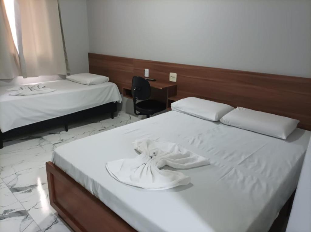 里奥克拉鲁Hotel Rio Claro的酒店客房配有两张床和一张书桌