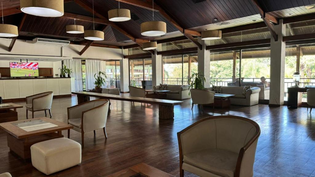 伊瓜苏港若爱查斯日欧诺酒店的大型大堂设有桌椅和窗户。