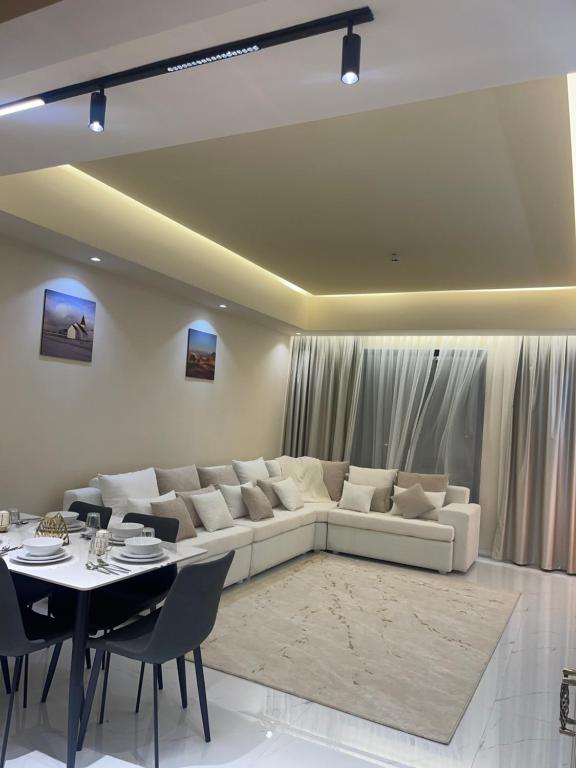 阿吉曼شقة فندقية ALzorah Ajman - الزوراء عجمان的客厅配有白色的沙发和桌子