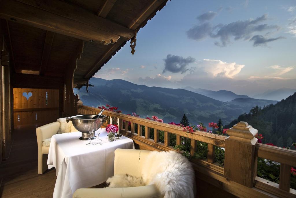 阿尔卑巴赫Luxus Chalet Bischofer- Bergwelt的山景阳台,配有桌椅。
