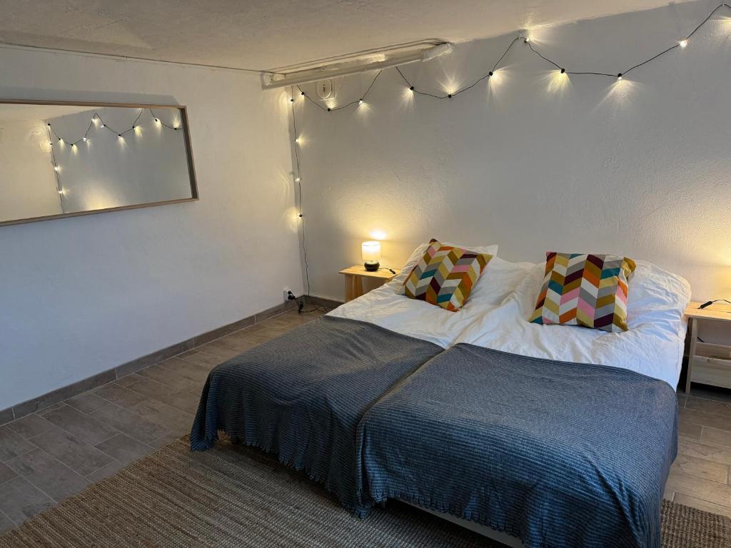 马尔默The Yellow House的卧室配有一张挂在墙上的灯光床。