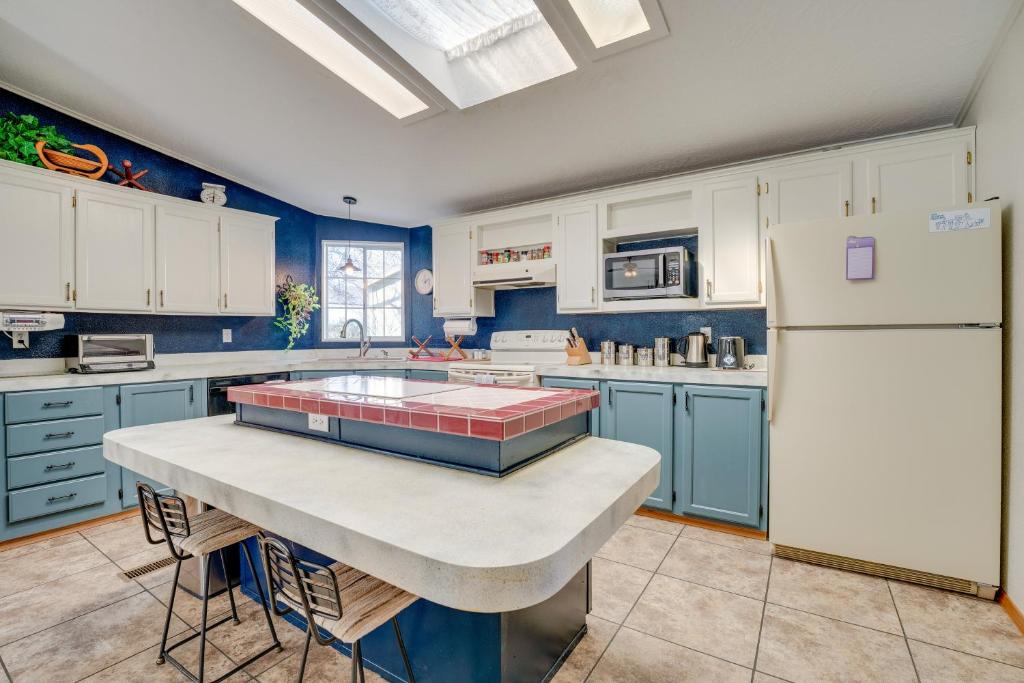 Idyllic Rock Island Home with Columbia River Views的厨房配有蓝色橱柜和白色冰箱