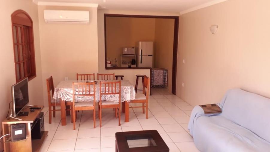 佩洛塔斯Sobrado na Praia do Laranjal的一间带桌椅的客厅和一间厨房