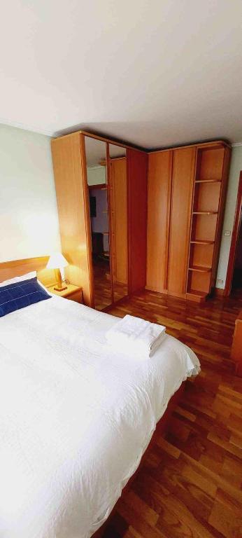 毕尔巴鄂HABITACIÓN EN BILBAO的卧室配有白色的床和木制橱柜。