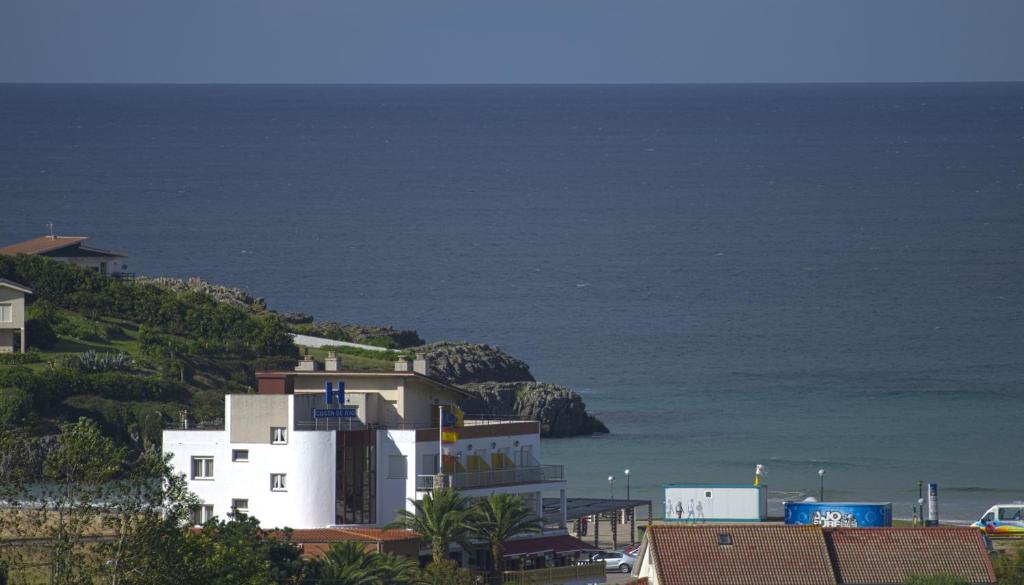 阿霍Hotel Costa de Ajo的海边小山上的白色建筑