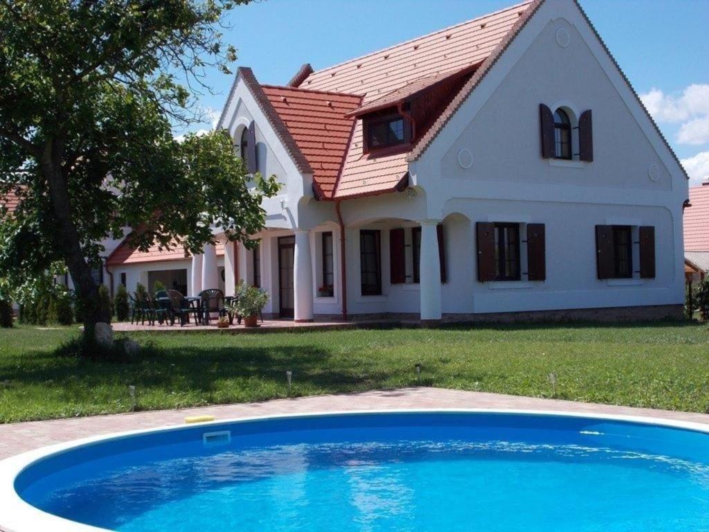 大瓦若尼Ferienhaus für Gruppen mit großem Garten, Terrasse und fünf Parkplätzen gegenüber von einer Reitschule的前面有一个蓝色泳池的房子