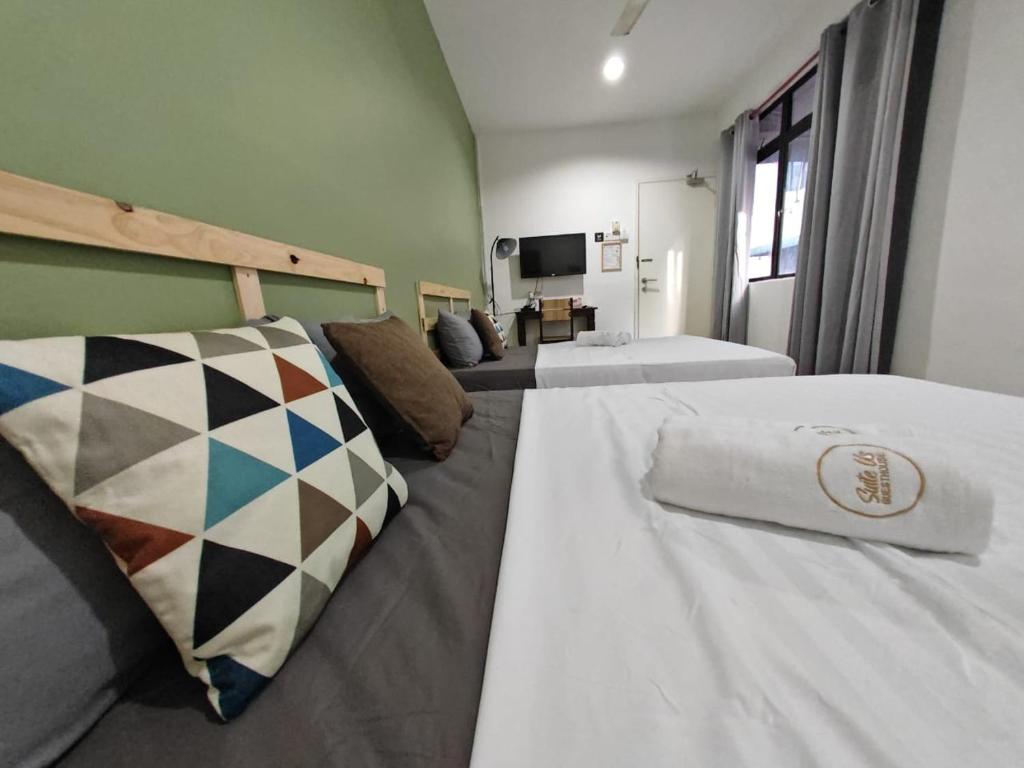 哥打巴鲁Suite Us Guesthouse Kubang Kerian的酒店客房设有两张床和电视。