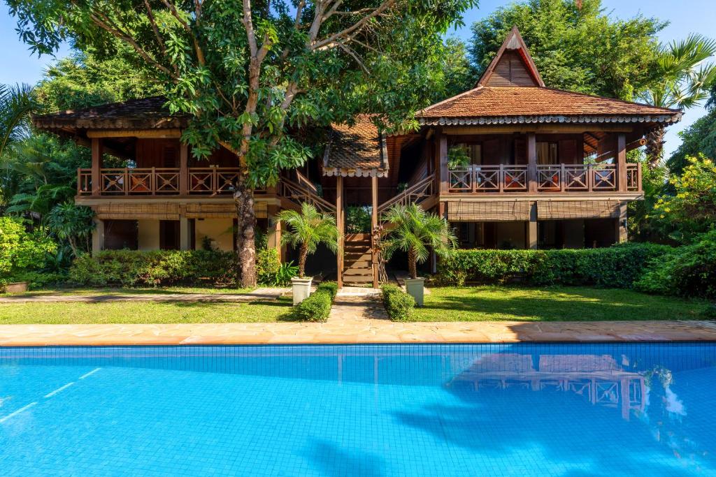 暹粒吴哥棕榈园酒店的房屋前有游泳池的房子