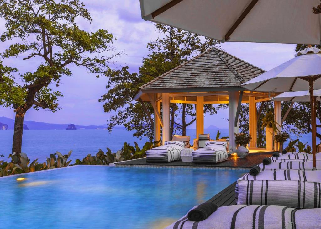 阁遥岛Cape Kudu Hotel, Koh Yao Noi的一个带椅子和凉亭的度假村游泳池