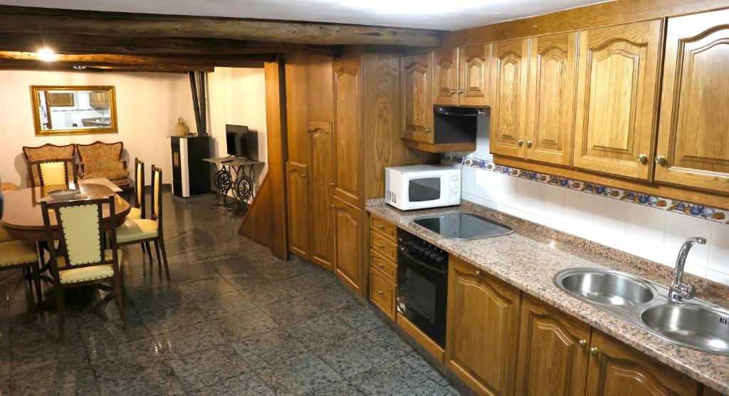 FolgosoA CASA DO POZO的厨房配有木制橱柜、水槽和微波炉