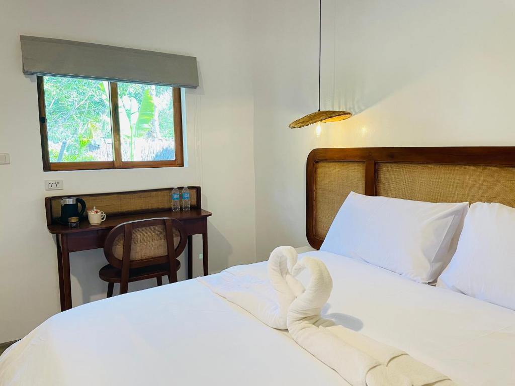 莫阿尔博阿MAAYONG HOSTEL的一间卧室配有一张带白色床单的床和一扇窗户。