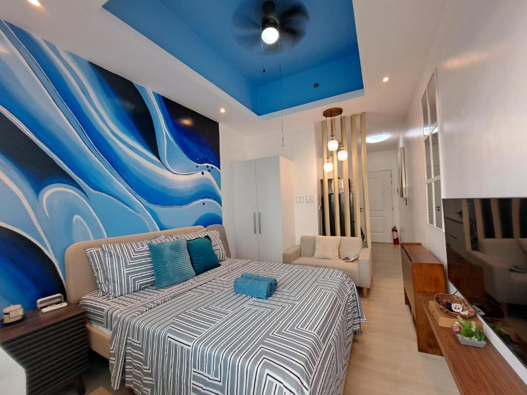 圣费尔南多Hailey's Crib @ Azure North的卧室配有一张床,墙上挂着一幅大画