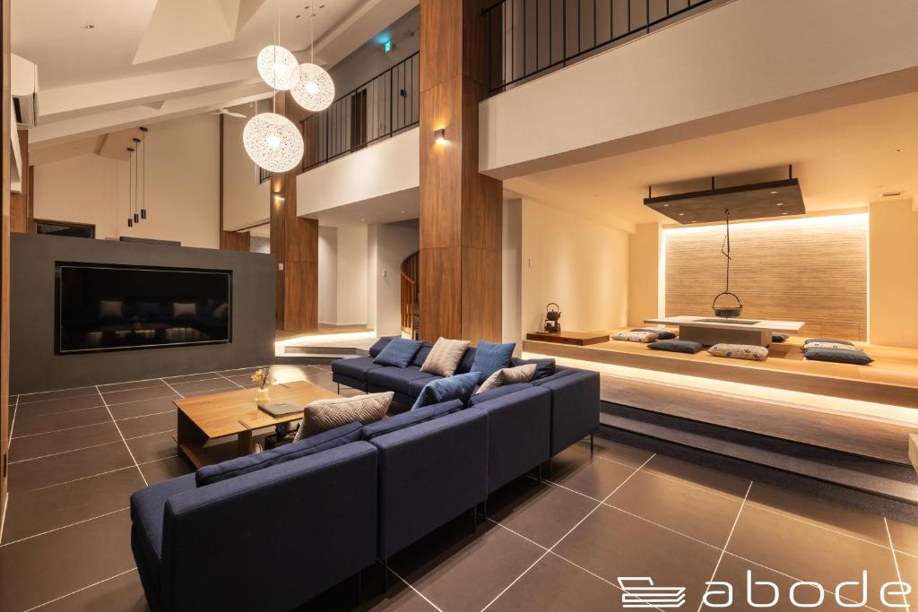 Onsensōabode villa GORA 八代別邸的客厅配有蓝色的沙发和电视