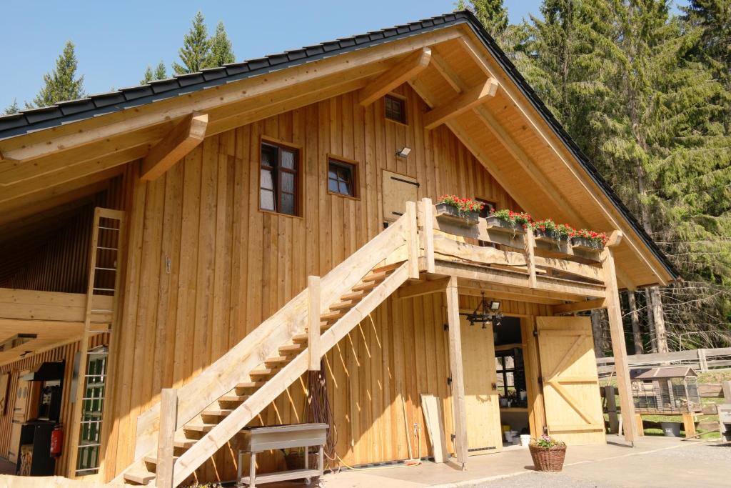 马瑟尔贝格Ferienwohnung Werraquell Hütte的一座木房子,上面有木楼梯