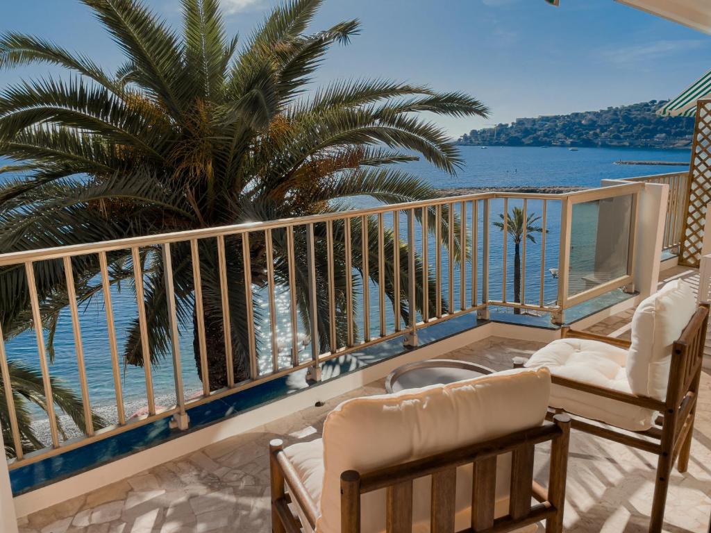 罗克布吕讷-卡普马丹Soleil Riviera Apartament Côte d’Azur的阳台配有椅子,享有海景。