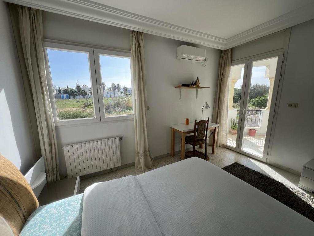 Chott Meriemappartement 14的卧室配有一张床、一张书桌和窗户。