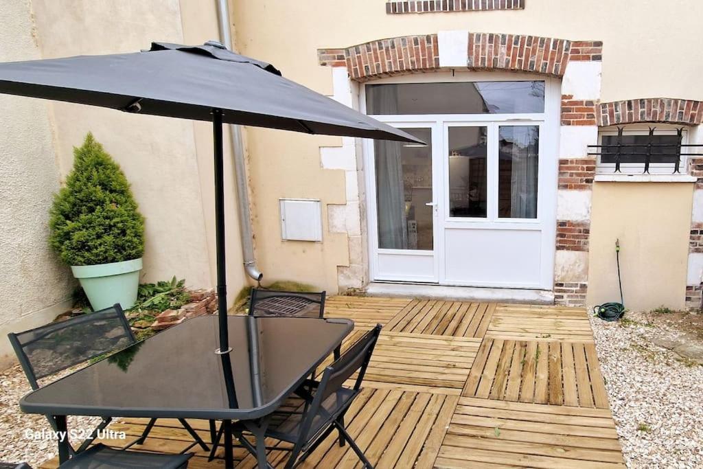 阿普瓦尼LE CHATEL BOURGEOIS的庭院内桌椅和遮阳伞