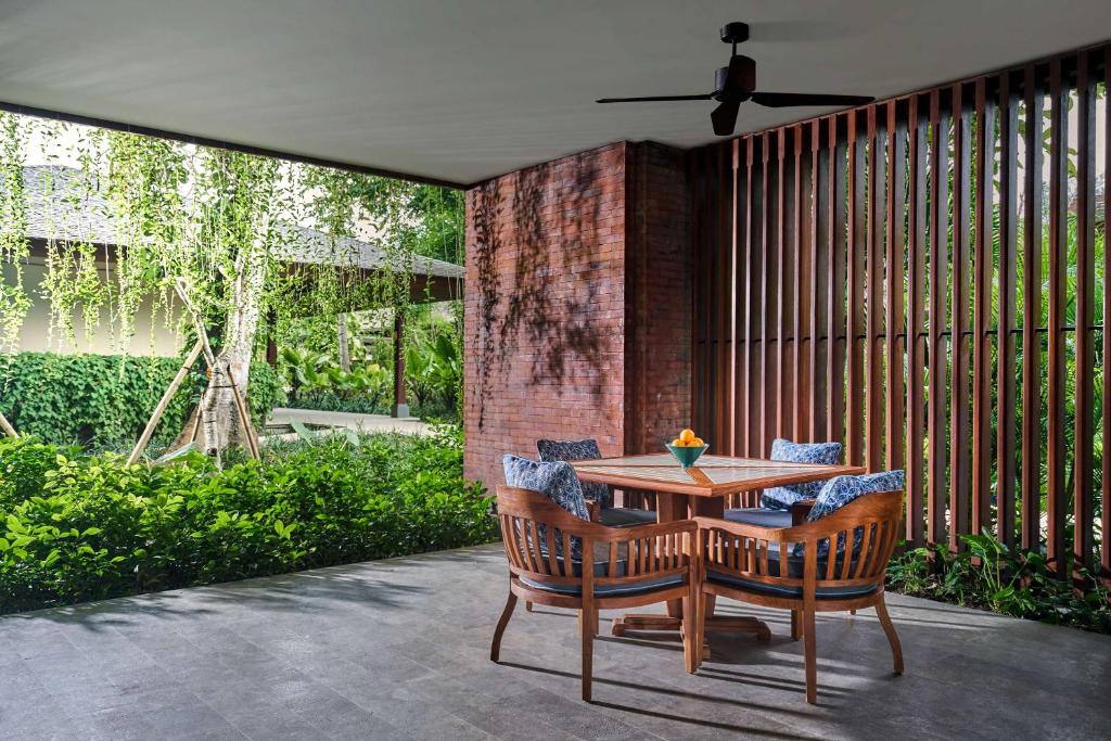沙努尔Andaz Bali - a Concept by Hyatt的庭院配有木桌和椅子