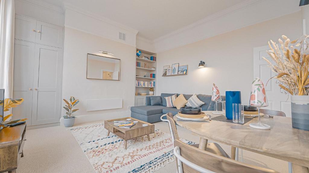 伯恩茅斯Burlington Mansions - Stunning Coastal Apartment的客厅配有桌子和蓝色沙发