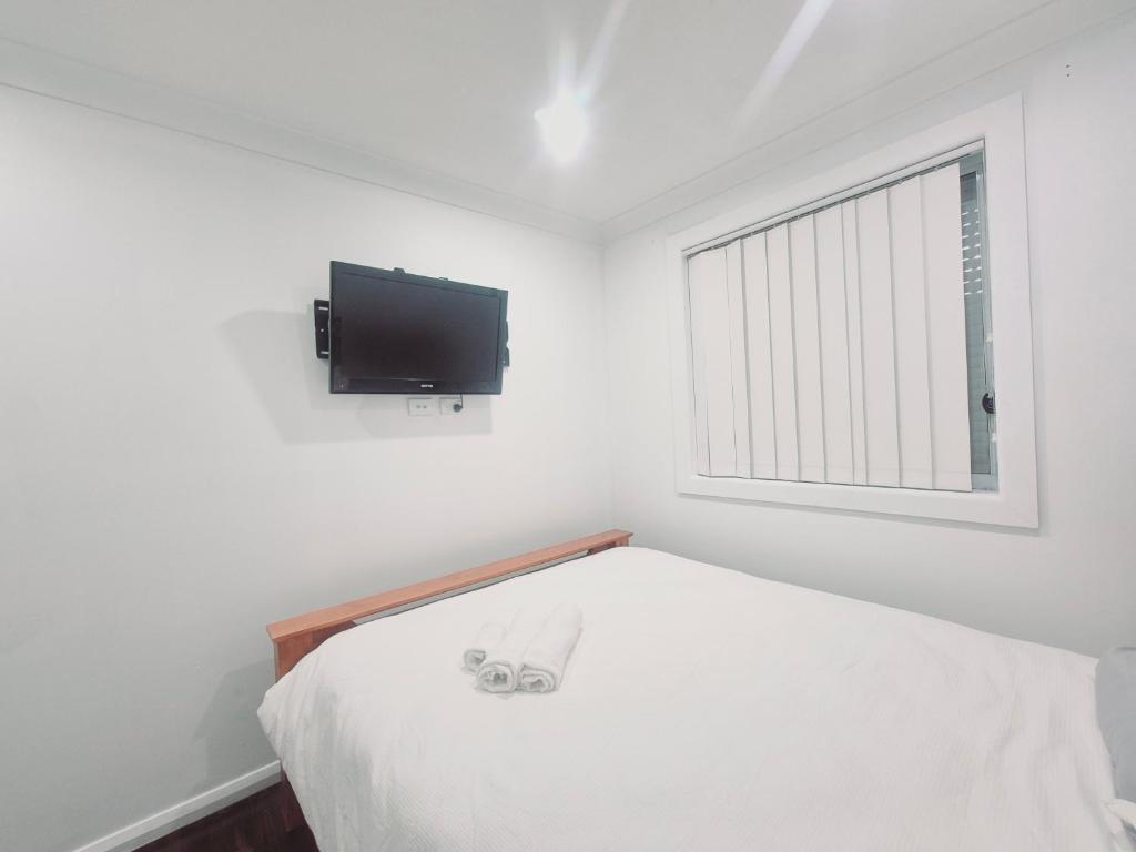 BidwillKaban Power 39的卧室配有一张床,墙上配有电视。