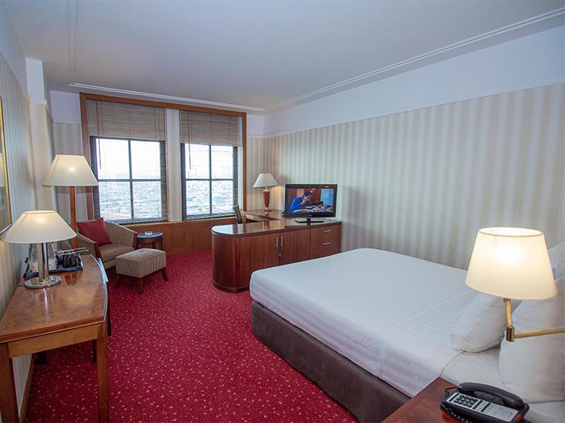 雅加达红顶会议中心酒店 的配有一张床和一张书桌的酒店客房